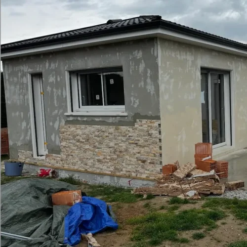 Maison en rénovation avec parement pierre et enduit gris par Milo facade en Haute-Garonne