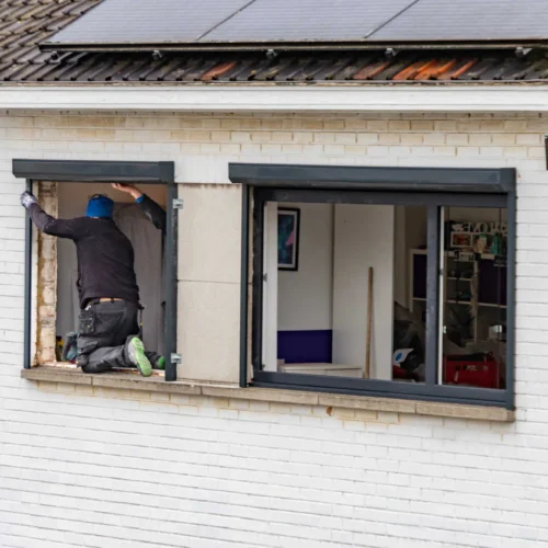 Ouvrier posant une fenêtre en rénovation de façade avec Milo facade en Haute-Garonne